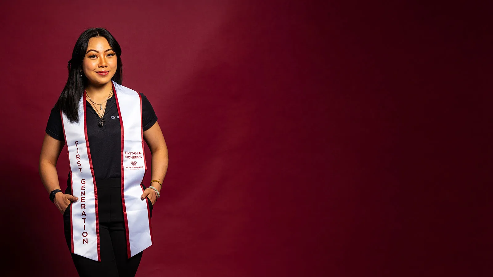 A ̽¥ student wearing a maroon and white sash with the words 'First Generation' on it