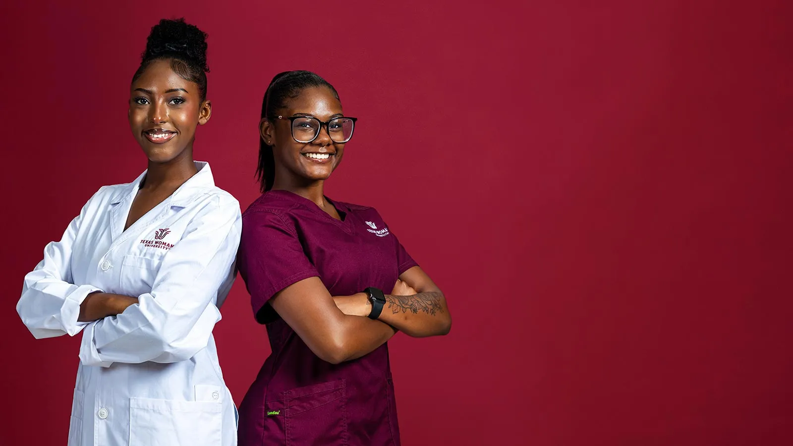 TWU students Karire Gashangu and Alivyah Stokes wearing university medical scrubs and lab coats