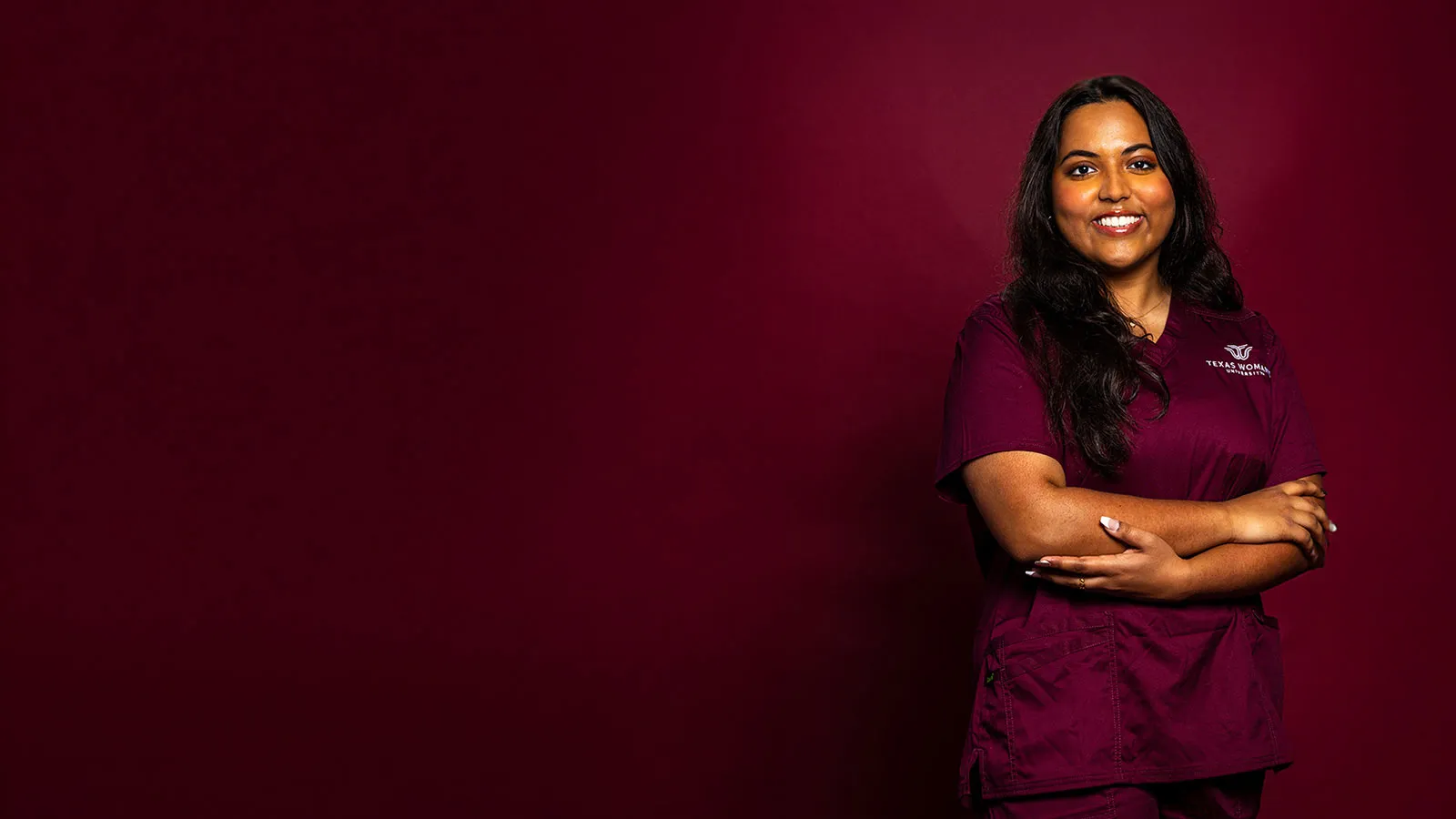 A TWU Nursing student wearing maroon scrubs