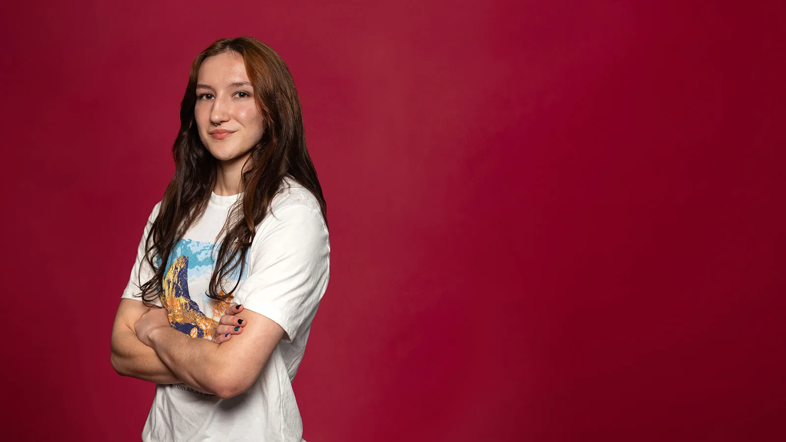 A 鶹ýAV Student with Arms Crossed and Wearing a T-Shirt