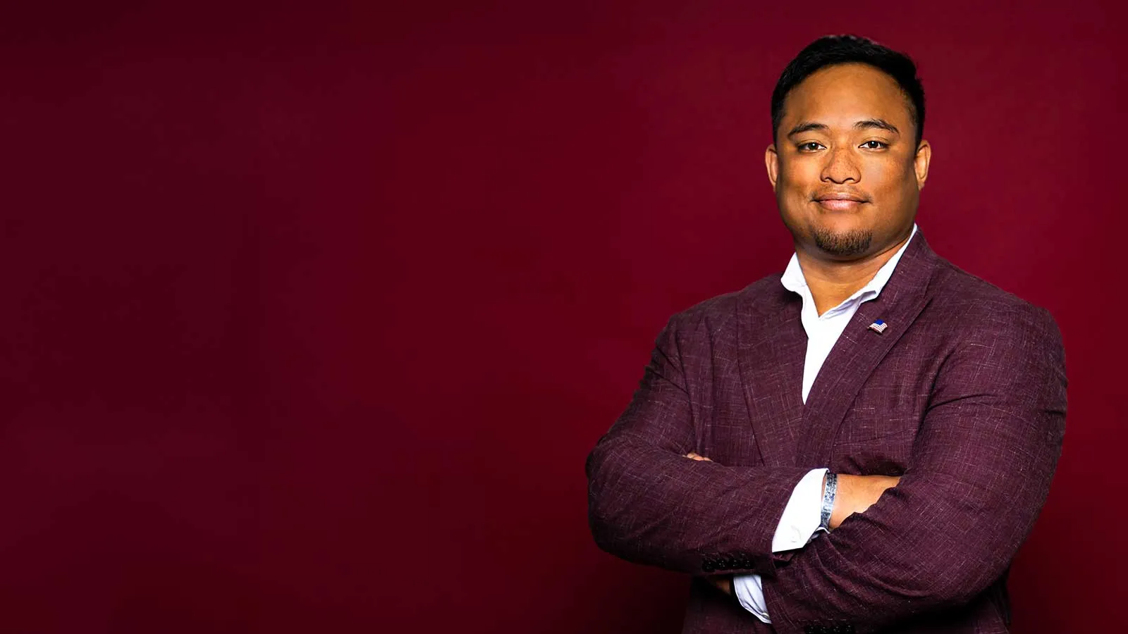 A TWU Student with Arms Crossed and Wearing a Maroon Sport Coat