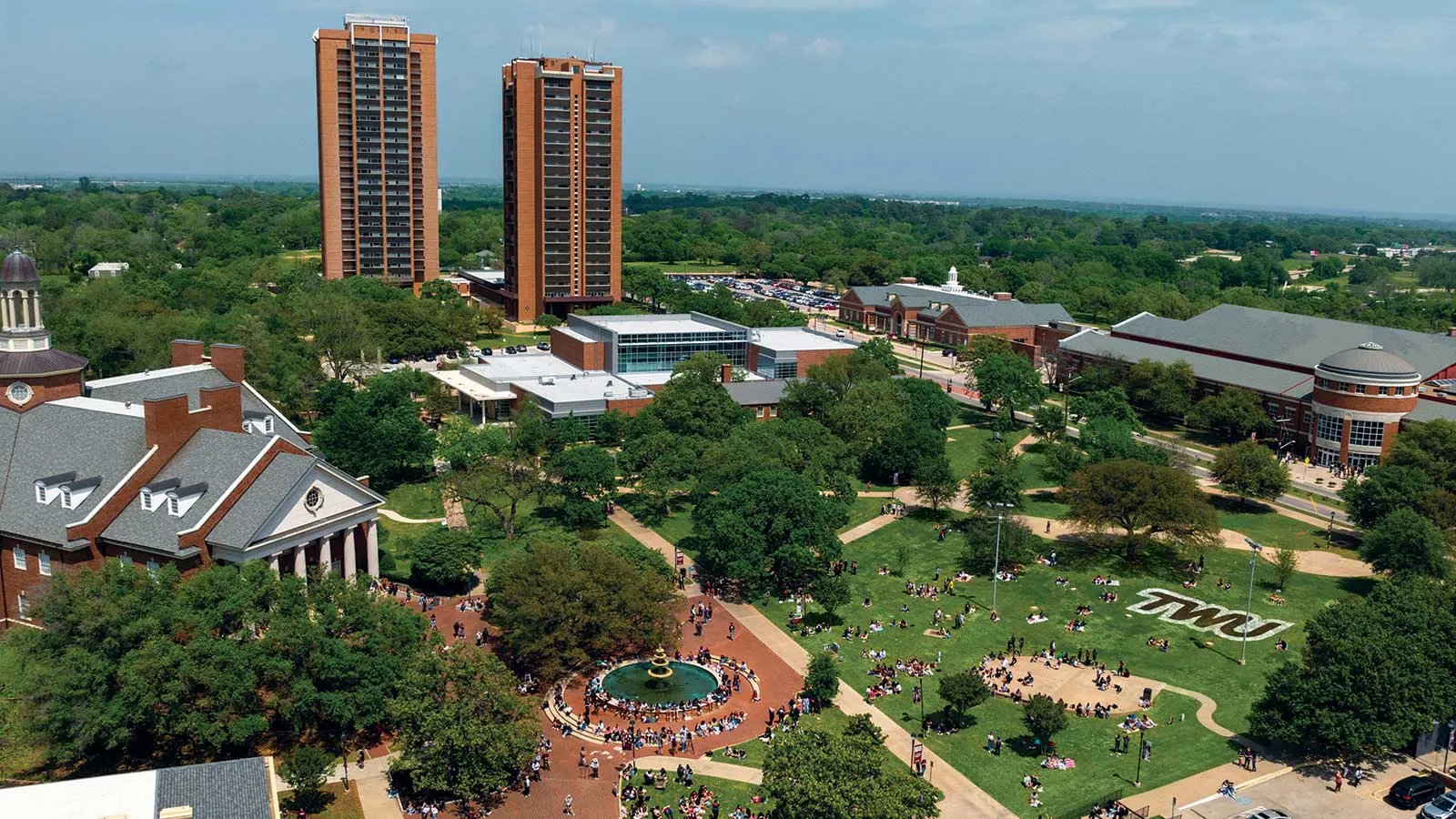 An aerial photo of the TWU Denton campus, showing crowds of students below