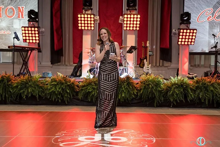 woman stands with microphone on dance floor