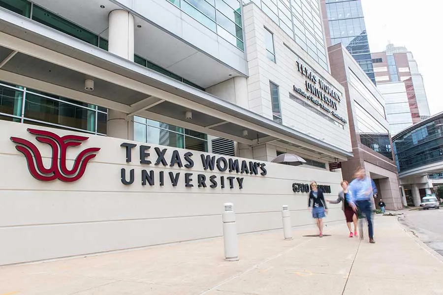 TWU signage outside the Houston campus as students walk by.