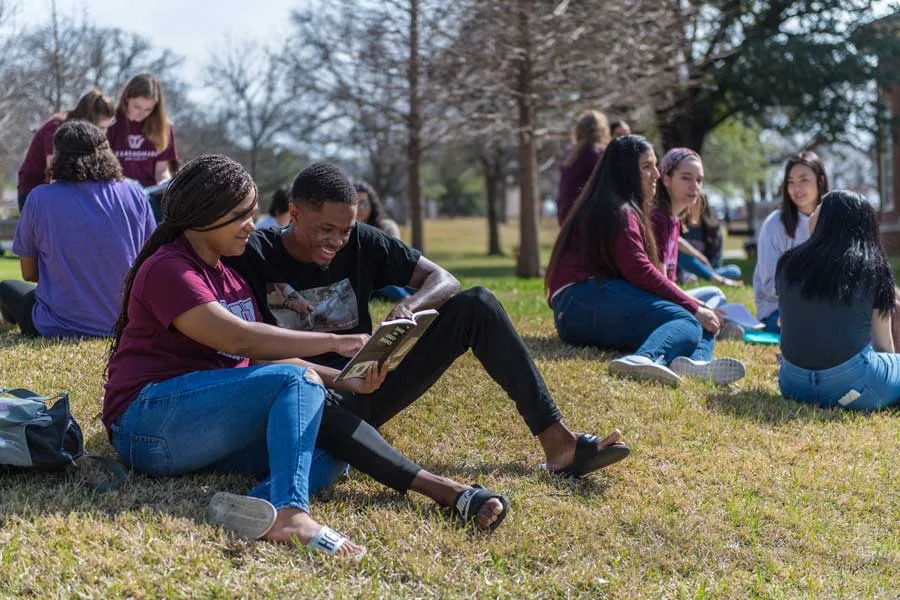 Students read and relax on the lawn at TWU's Denton campus.