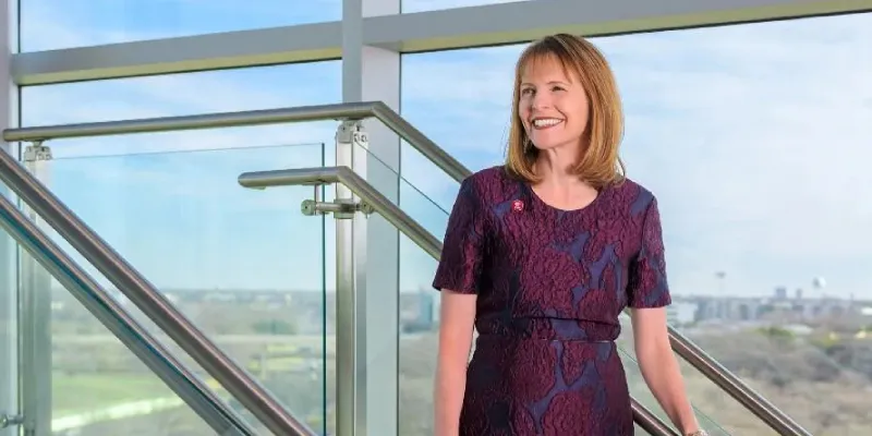 TWU Dallas president Monica Christopher stands in front of a glass wall through which Dallas is visible.