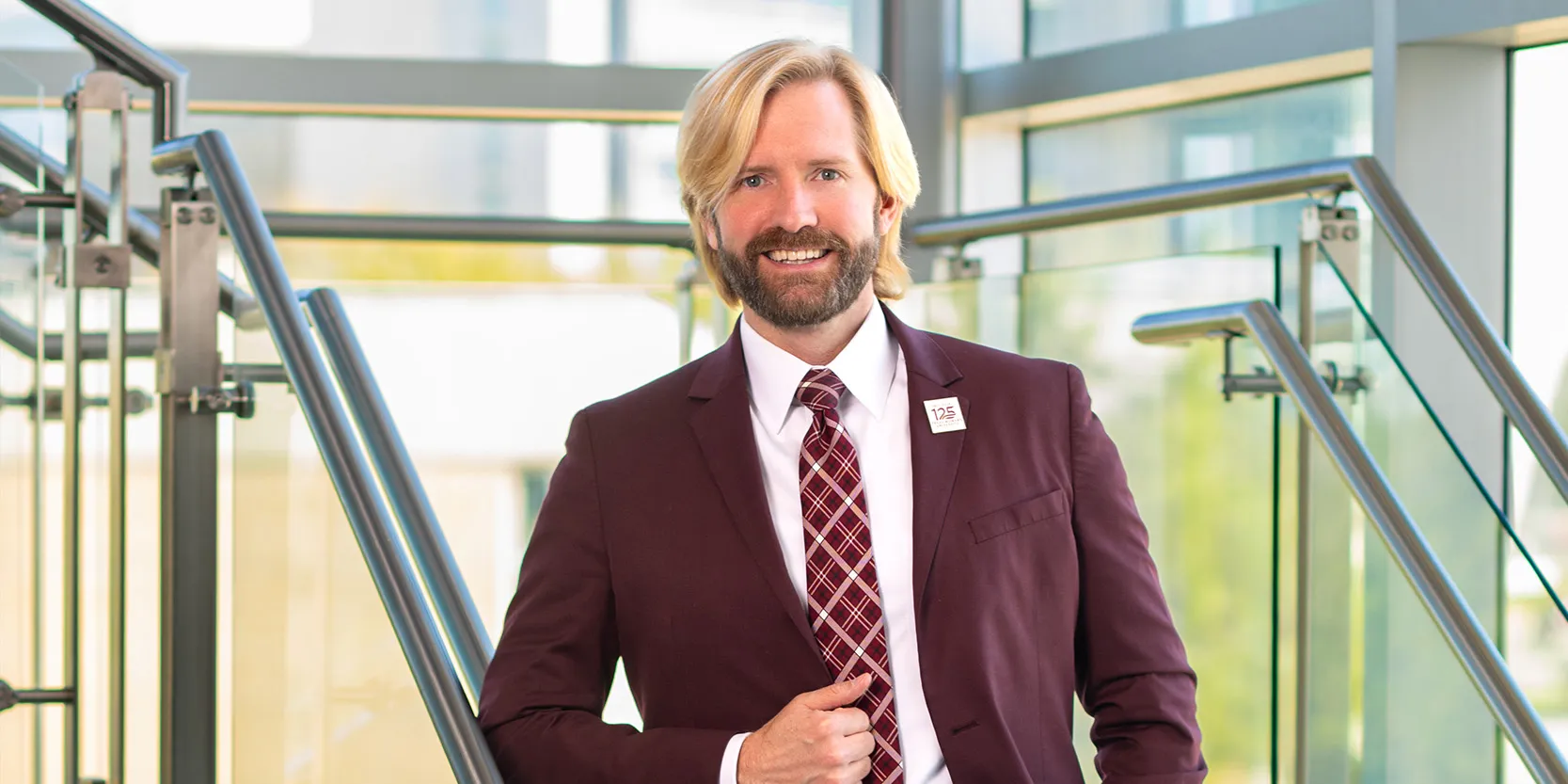 Interim TWU Dallas president Christopher Johnson stands in front of a glass wall through which Dallas is visible.