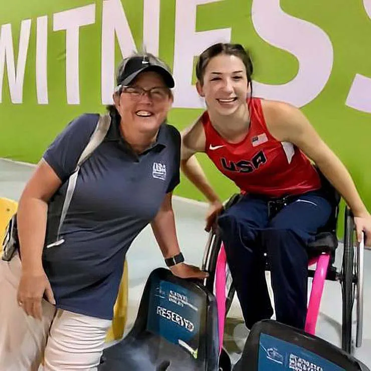 Cathy Sellers smiles next to a young USA Paralympic athlete in Doha, Qatar.