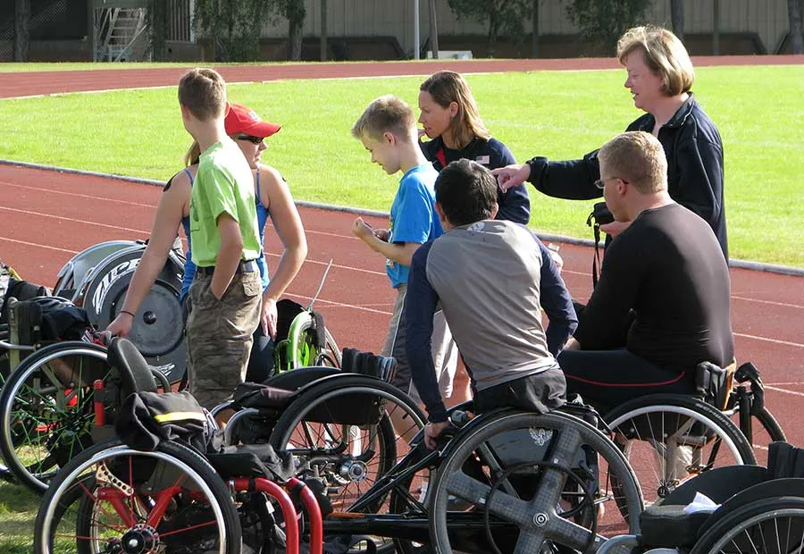 Cathy Sellers directs young Paralympic athletes on the field