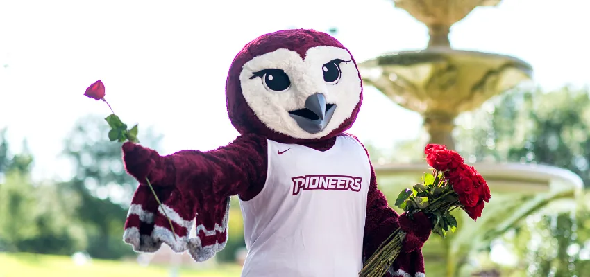 Oakley, TWU's mascot, holding roses 