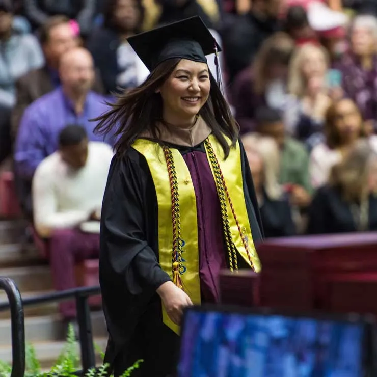 A TWU graduate in commencement cap and gown