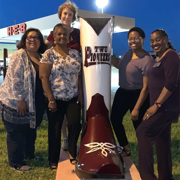 Rio Grande Valley Alumni Chapter pose in front of the giant TWU Pioneers boot in Mercedes, TX