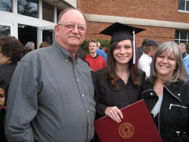 Sarah McVean with her parents holding he diploma from TWU