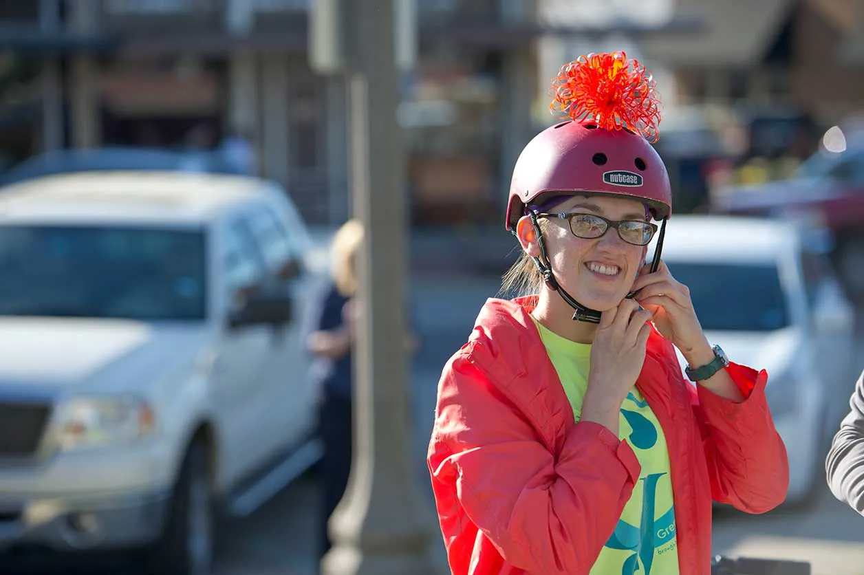 A student putting on her helmet at the Denton downtown square during the ARTSWALK 2016 bike parade