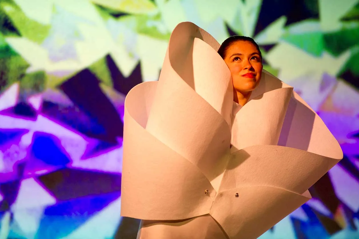 a student dance performer's head comes out of a giant flower costume