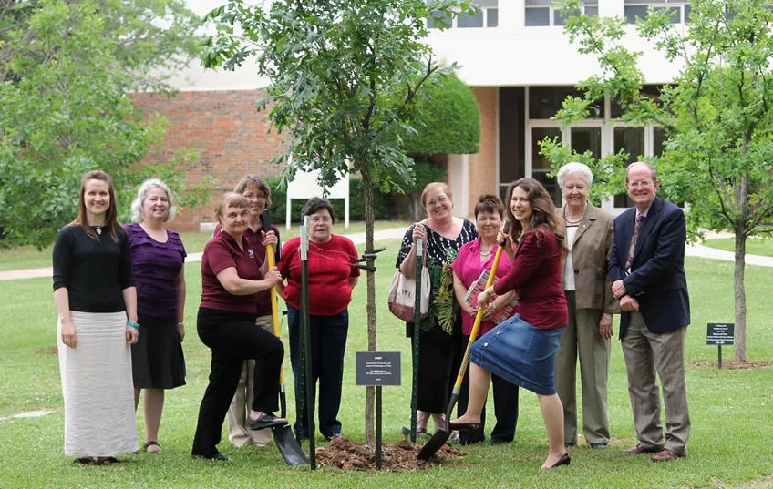 Asset members plant a tree as a celebration of 30 years at TWU. 