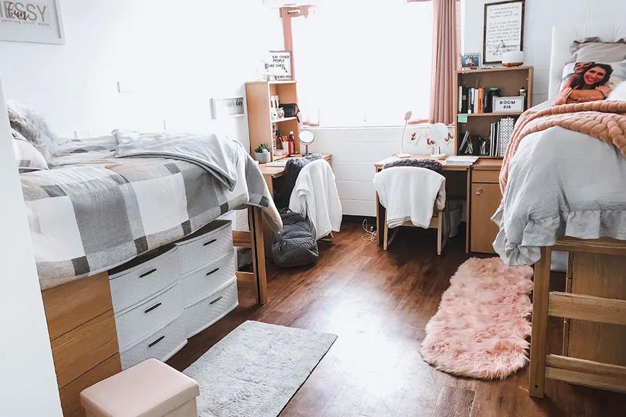 A cozy pink and gray decorated dorm room.