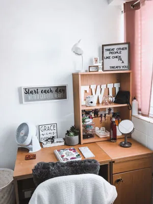 A cozy pink and gray decorated dorm room.	