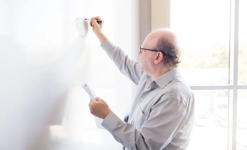 Michael Bergel draws structure for his patented anti-cancer compounds on a whiteboard. 