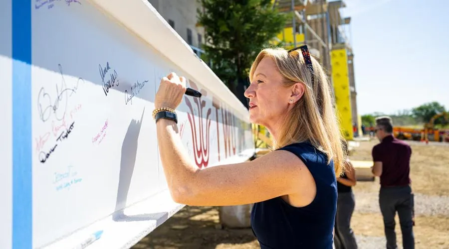 TWU Executive Vice President of Academic Affairs Angela Bauer signs the final beam for the upcoming health sciences building before its placement