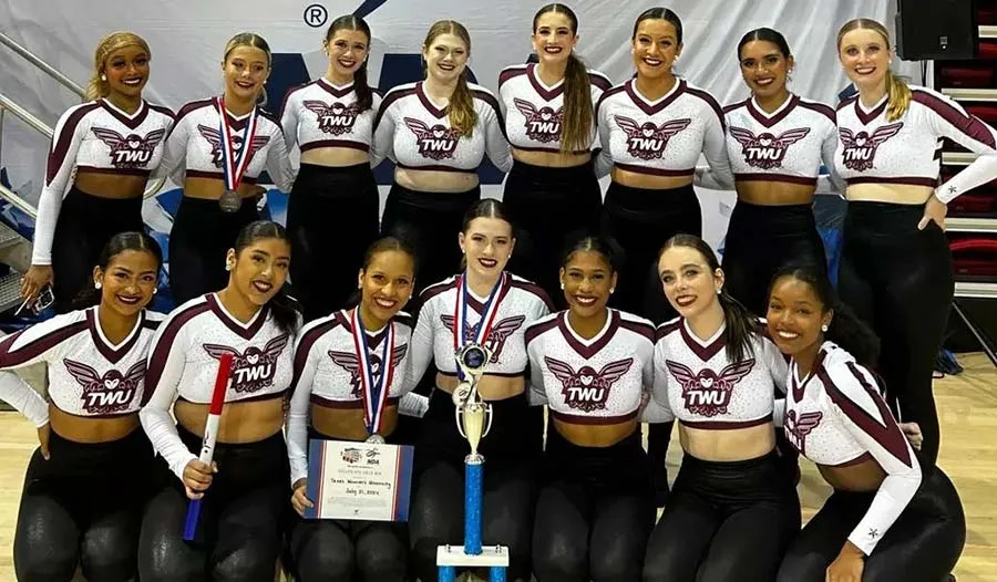 TWU dance team poses with their first-place trophy and Gold Paid Bid to the 2025 National Dance Alliance
