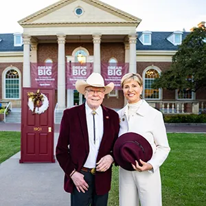 Chancellor Carine Feyten and husband Chad Wick stand in front of Hubbard Hall on TWU's Denton campus