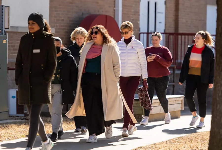 Chancellor Feyten walks across the TWU Denton campus with a group of faculty, staff, and students