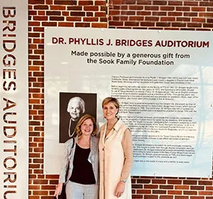 Chancellor Feyten stands with Dr. Sandy Sook in front of the newly-christened Phyllis J Bridges Auditorium at the TWU Denton Student Union building