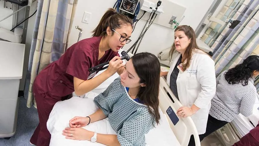 TWU nursing students practice giving a check-up to a patient under the watch of an instructor