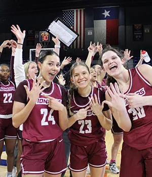 Members of the TWU basketball team celebrating a Lone Star Conference win