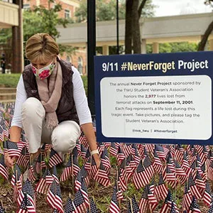 Chancellor Carine Feyten plants flags in the Denton campus Free Speech Area for the Student Veterans Association's annual September 11 memorial