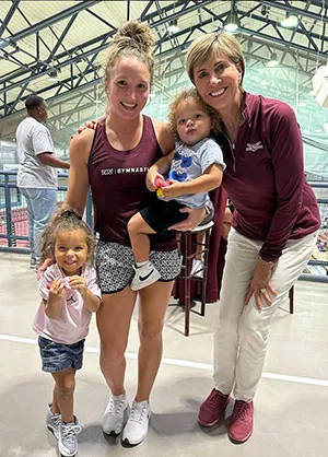 Chancellor Carine M. Feyten with Texas Woman’s Gymnastics Associate Head Coach Kristen Harold and her children