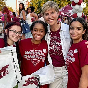 Chancellor Feyten with 3 students at the 2025 Block Party on the Denton campus