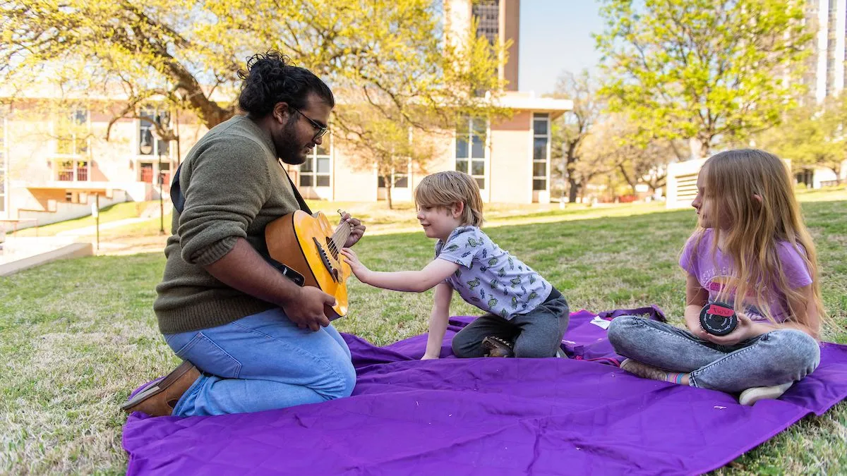 TWU music therapy student Abel Abraham works with children on the Denton campus.