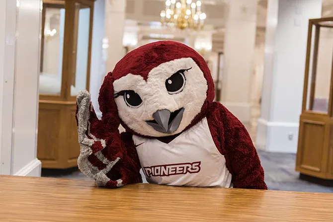 Oakley holding his head as if he has a headache in the library.