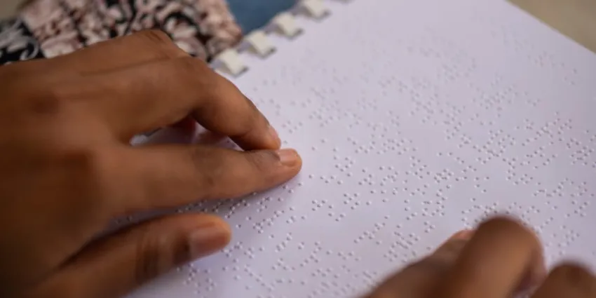 Demetria Ober reads a Spanish textbook in braille. 