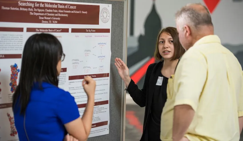 Chem/Biochem student Claudette Fraire presents her research poster to two guests at Golden Triangle Mall