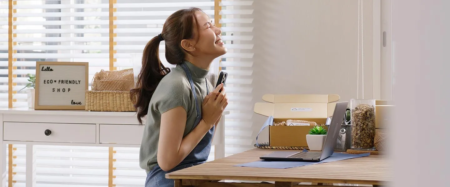 A young woman sits in her new business looking excited