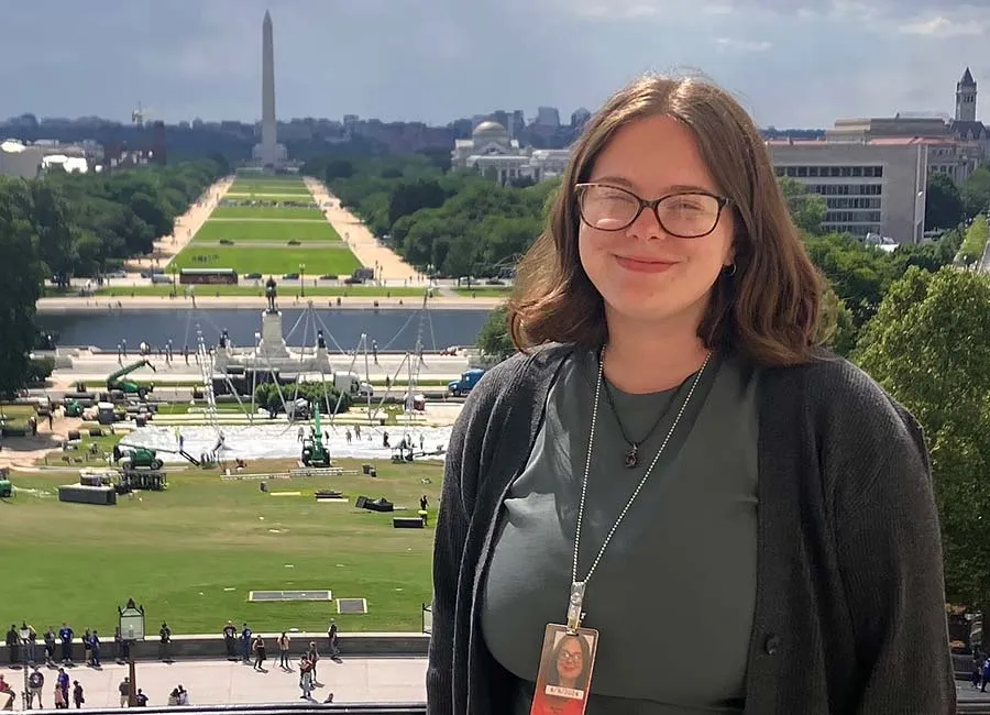 A TWU student working in Washington DC, with the Washington Monument in the background