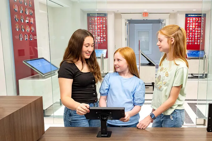Three kids play the iCivics game and virtually run a fictitious county.