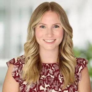 a headshot of bre hasten in a bright white office