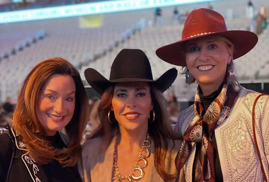 From left: TWU alumna Leigh Glendenning ('79 BS), alumna Stacie McDavid ('80 BS), and Chancellor Carine Feyten, all wearing western clothing