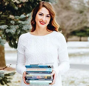 Katie McWain holding a stack of books