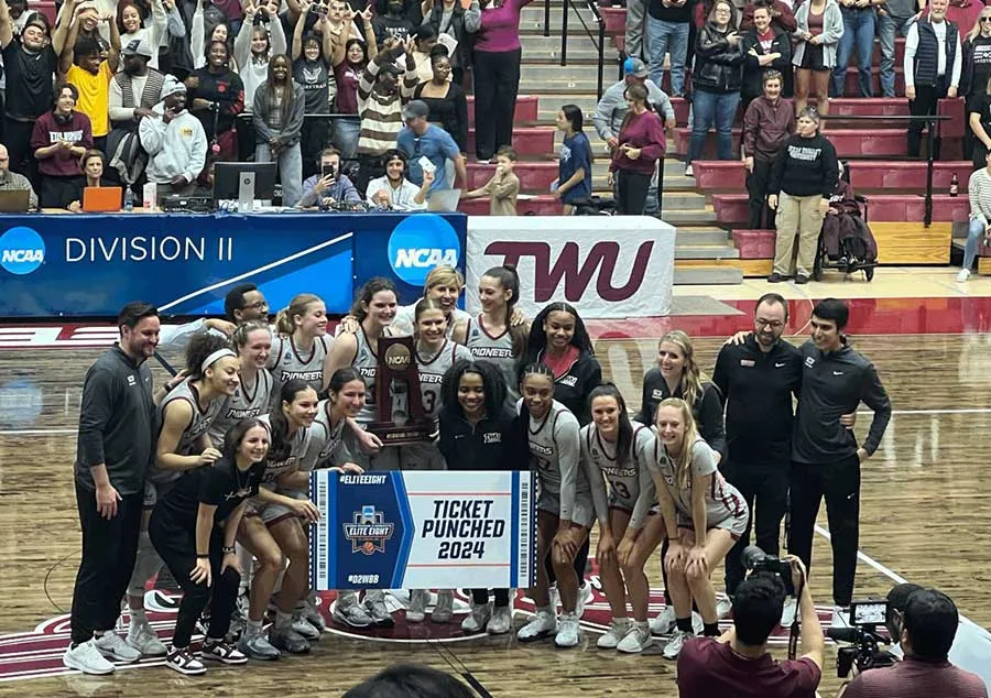 Chancellor Feyten stands with the TWU women's basketball team after a win advancing them to the D 2 Elite 8 for the first time