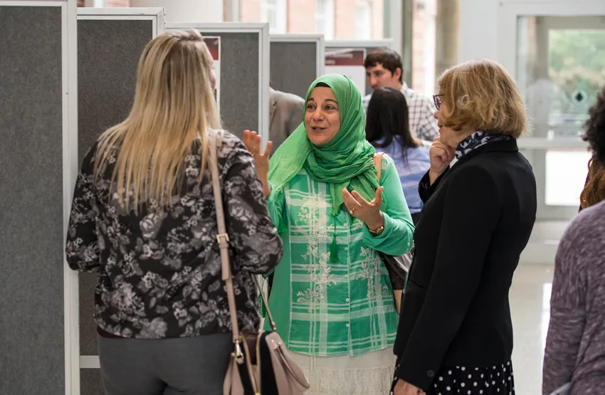 Associate professor Manal Rawashdeh-Omary, PhD, discusses research with guests at TWU's annual Celebration of Science event. 