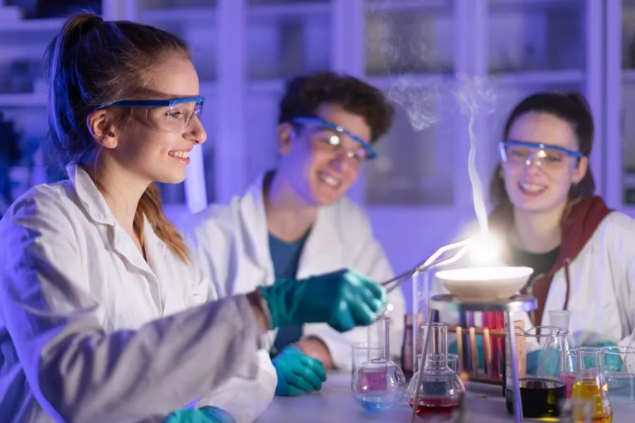 Three students conducting chemistry experiments in the lab 
