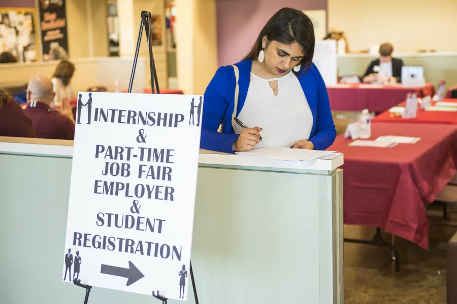 A woman filling out an application at the Internship and Part-Time Job Fair.