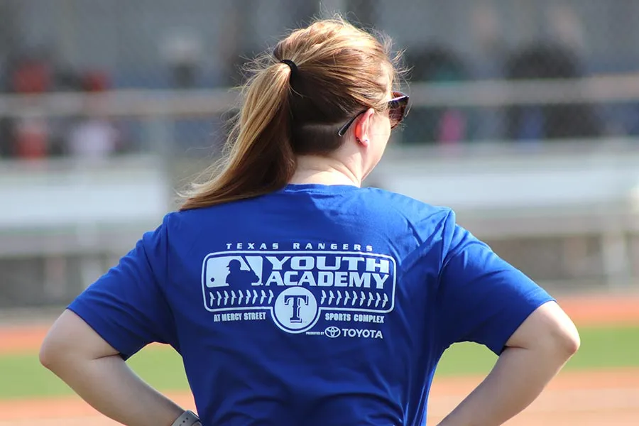 TWU alum Jesse Malone has her back turned with the Texas Ranger Youth Academy logo showing on the back of her blue shirt