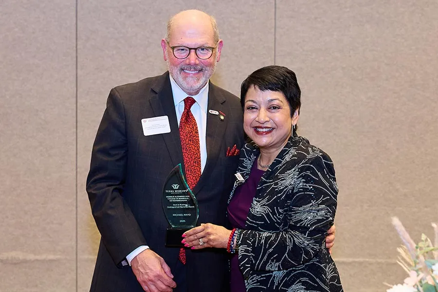 Michael A. Mayo stands next to Dean Yelkur, holding an award