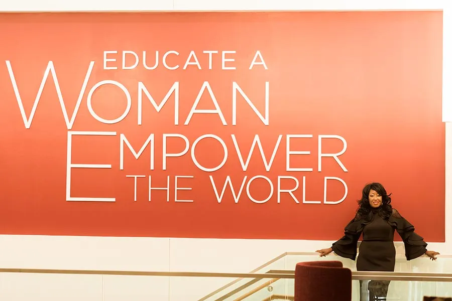 èƵ graduate student Bridget Roberts stands to the right of the Educate a Woman, Empower the World